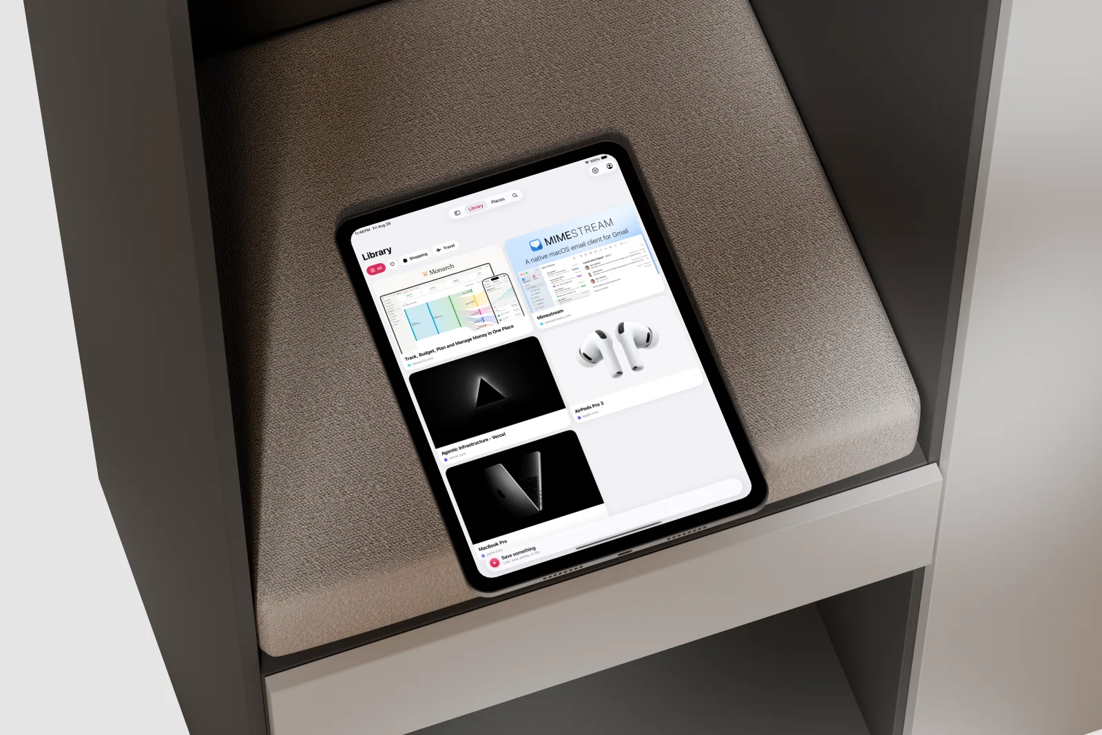 FaveNest on an iPad Pro resting on a textured shelf cushion, showing a spacious grid of saved links in the Library.